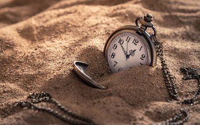 Карманные часы на цепочке в песке 