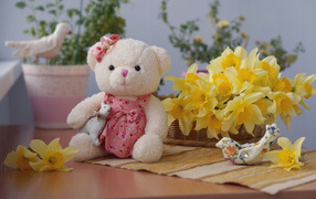 Плюшевый мишка на столе с букетов нарциссов