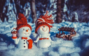 Две статуэтки снеговиков на снегу