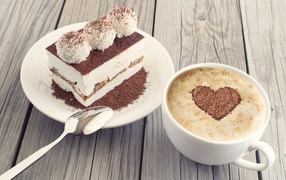 A cup of cappuccino with a cake on the table