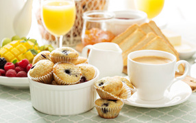 Чашка кофе с кексами на столе 