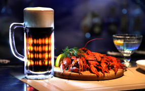 A glass of beer with boiled crawfish on the table