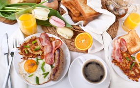 Сытный завтрак на столе с букетом тюльпанов 