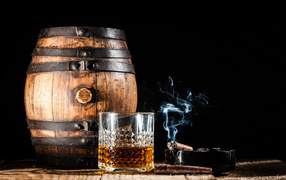 A keg of rum, with a glass of whiskey and a cigar on a black background