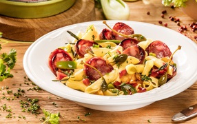 Тарелка макарон с колбасой и зеленью