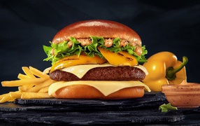 Аппетитный гамбургер с картофелем фри, болгарским перцем и соусом