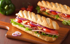 Appetizing sandwich with ham, lettuce, tomatoes and onions