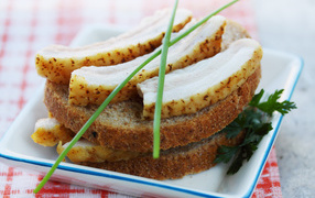 Черный хлеб с салом и зеленью на столе