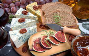 Сыр на столе с инжиром и кусками хлеба