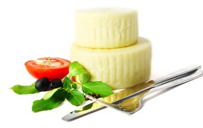 Cheese with tomato, cutlery, olives and herbs on white background
