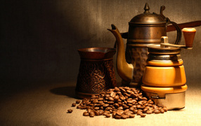 Кофемолка, турка, чайник и кофейные зерна на столе