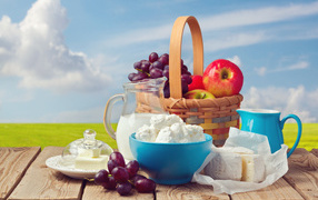 Творог с молоком на столе с виноградом и яблоками 