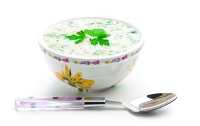 Аппетитная вкусная окрошка в тарелке на белом фоне с ложкой 