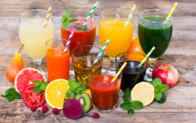 Свежевыжатые соки на столе с овощами и фруктами