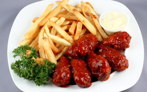 Meatballs in sauce with French fries and parsley on a plate