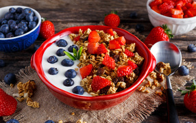 Muesli with yoghurt, strawberries and blueberries for breakfast