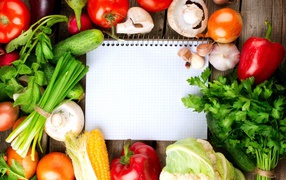 Блокнот со свежими овощами на столе 