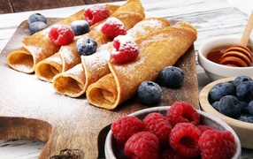 Блинчики с ягодами черники, малиной и сахарной пудрой