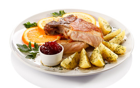 Potatoes with meat and slices of orange on a plate