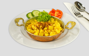 Картофель с овощами на белой тарелке