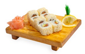 Роллы на деревянной доске с лимоном и имбирем