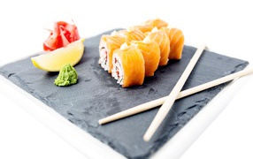 Роллы с красной рыбой на тарелке с палочками