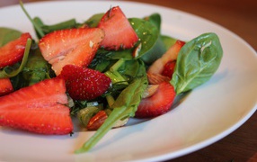 Salad from leaves of arugula and strawberries