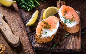 Бутерброды с сыром и красной рыбой на разделочной доске