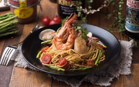 Спагетти с морепродуктами на черной тарелке