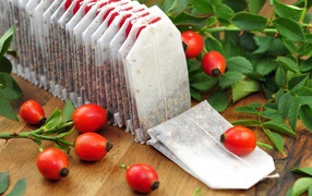 Tea bags on the table with wild rose berries