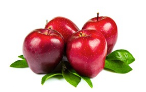 Красивые красные яблоки с зелеными листьями на белом фоне