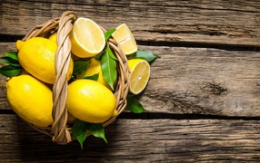 Beautiful yellow lemons in a basket on a wooden table
