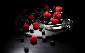 Berries of blueberries, raspberries and blackberries on a black background