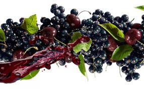 Black currant with a cherry and juice on a white background