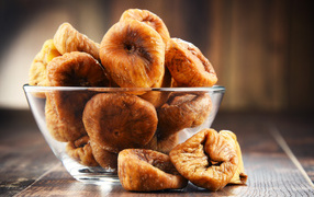 Инжир в стеклянной вазе на столе 