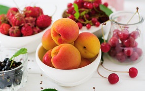 Свежие абрикосы на столе с ягодами крупным планом