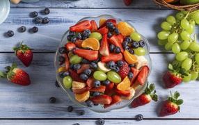 Фрукты и ягоды в тарелке на столе 