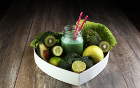 Зеленые овощи и фрукты в тарелке с баночкой смузи
