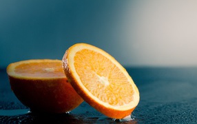 Оранжевый апельсин на мокром столе