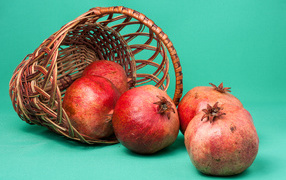 Pomegranate fruits in a basket on a blue background
