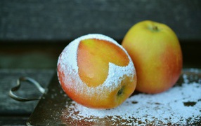 Ripe apple with powdered sugar on the table