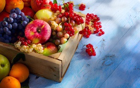 Спелые сочные ягоды и фрукты на столе в деревянном ящике