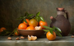 Ripe mandarins on a table with a jug