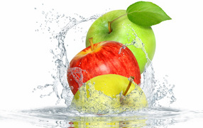 Три яблока в брызгах воды на белом фоне