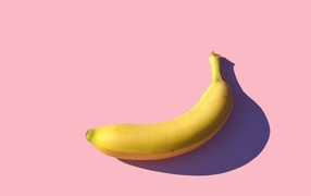 Желтый банан на розовом фоне
