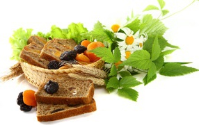 Сухофрукты с хлебом и цветами ромашки на белом фоне