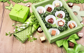 Коробка шоколадных конфет с подарком на столе