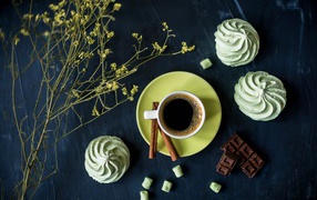 A cup of coffee with meringue and chocolate on the table