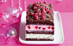 Кусок пирога с шоколадом и малиной на розовом фоне