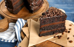 Кусок вкусного шоколадного торта на столе с кофейными зернами